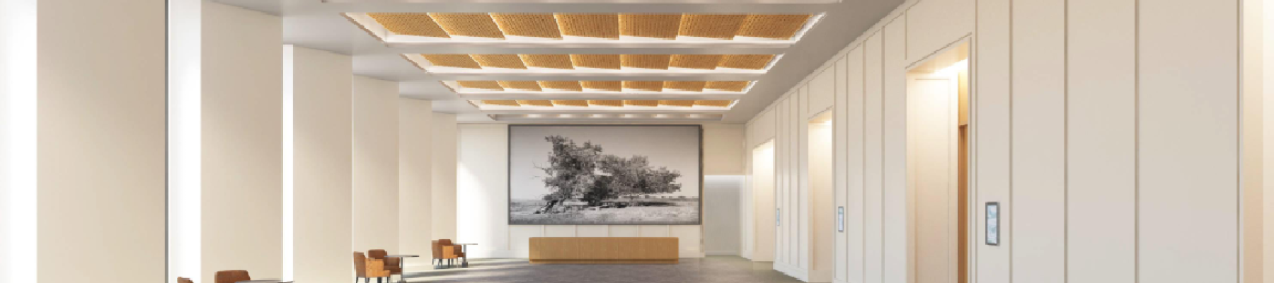 A spacious, modern lobby with high ceilings, warm wood ceiling panels, gray carpet, white walls, seating along the sides, and a reception desk at the far end.