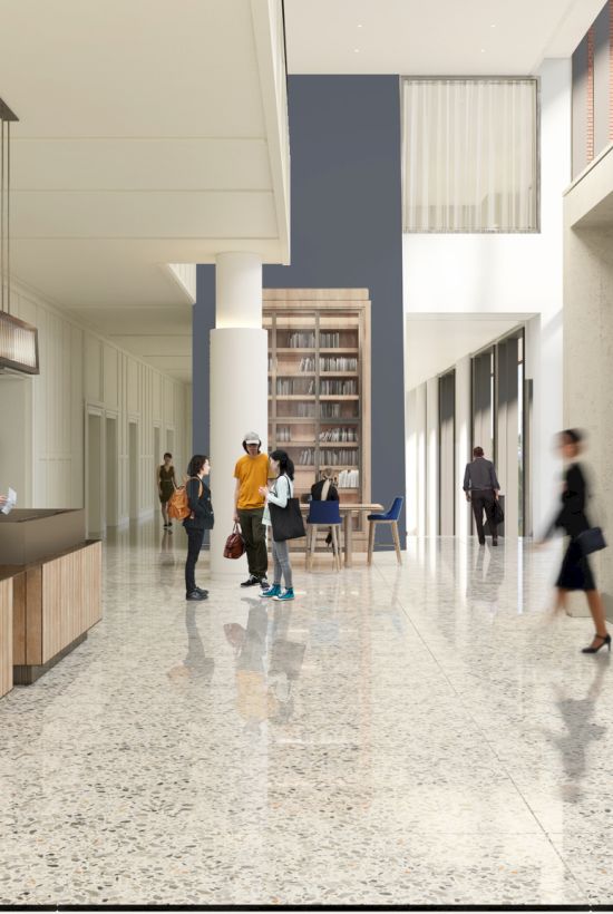 A modern office lobby with a reception desk, polished floors, people walking, and glass doors leading outside; bright, spacious, welcoming.