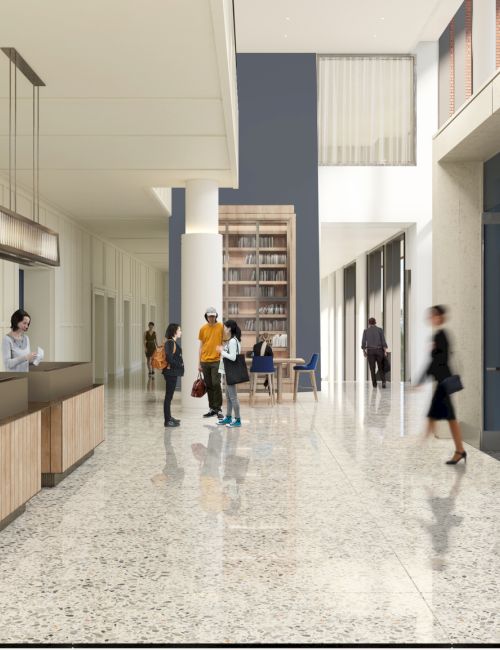 A bright, modern lobby with a reception desk, people walking and talking, glossy tiled floor, and large windows along one wall.