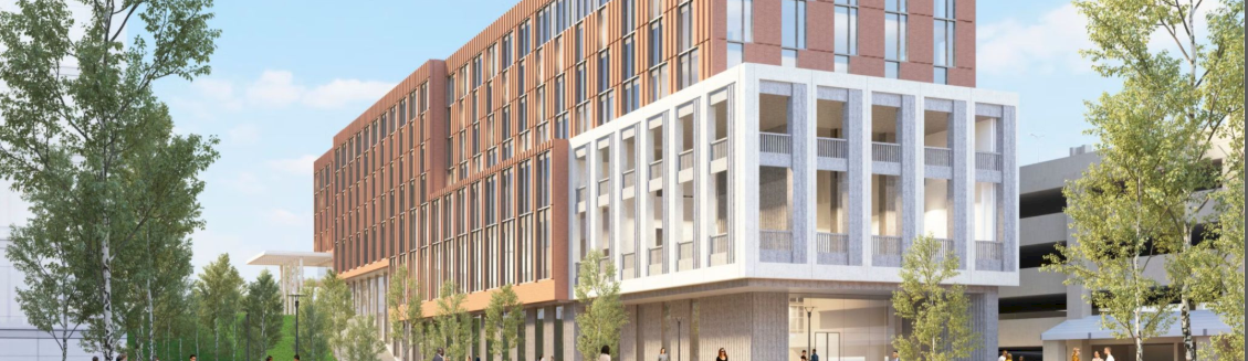 A modern multi-story building with brick and white frame facade, near a water feature, trees, and pedestrians in a campus-like setting.